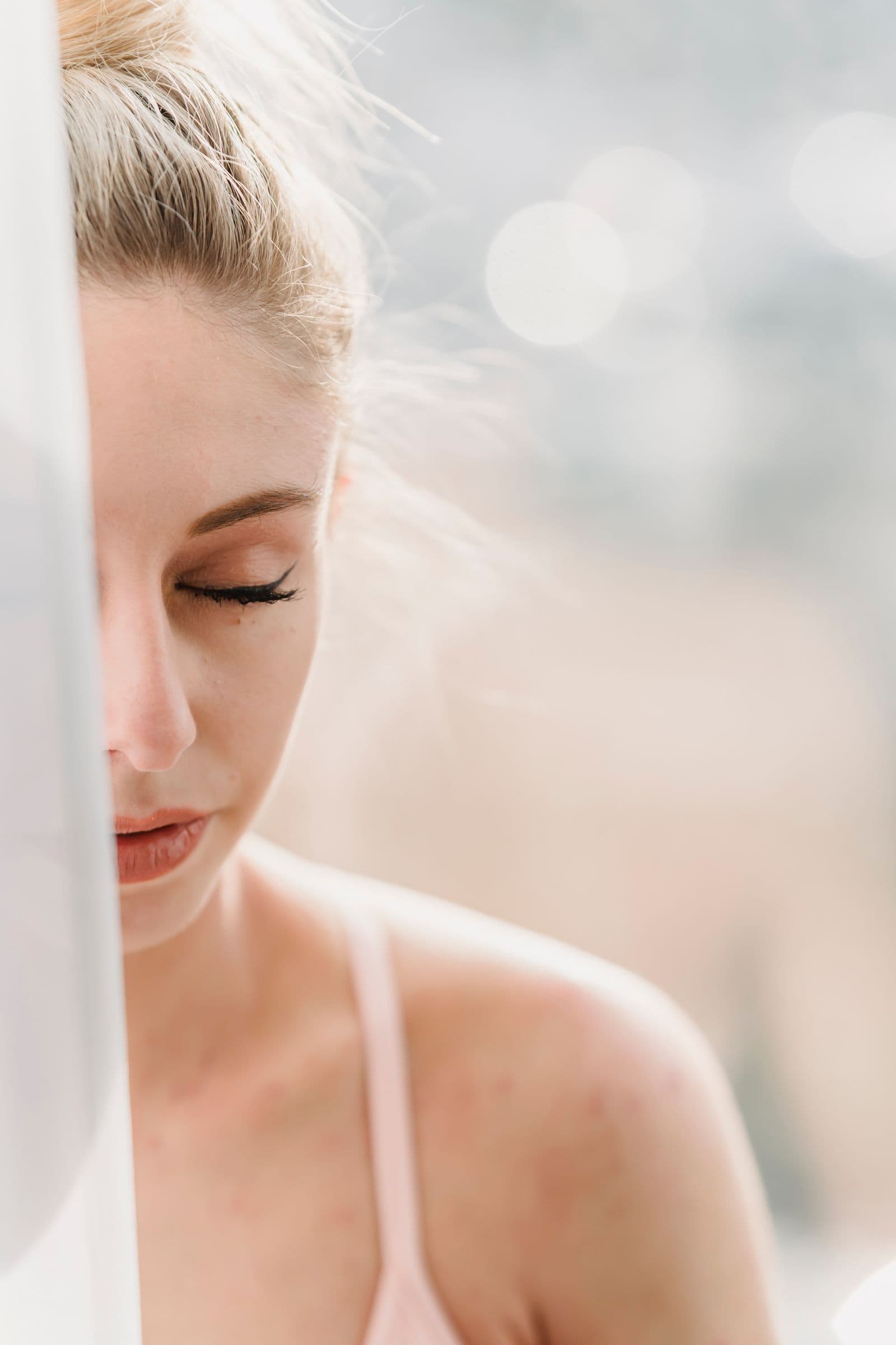 Woman with closed eyes resting in soft morning window light