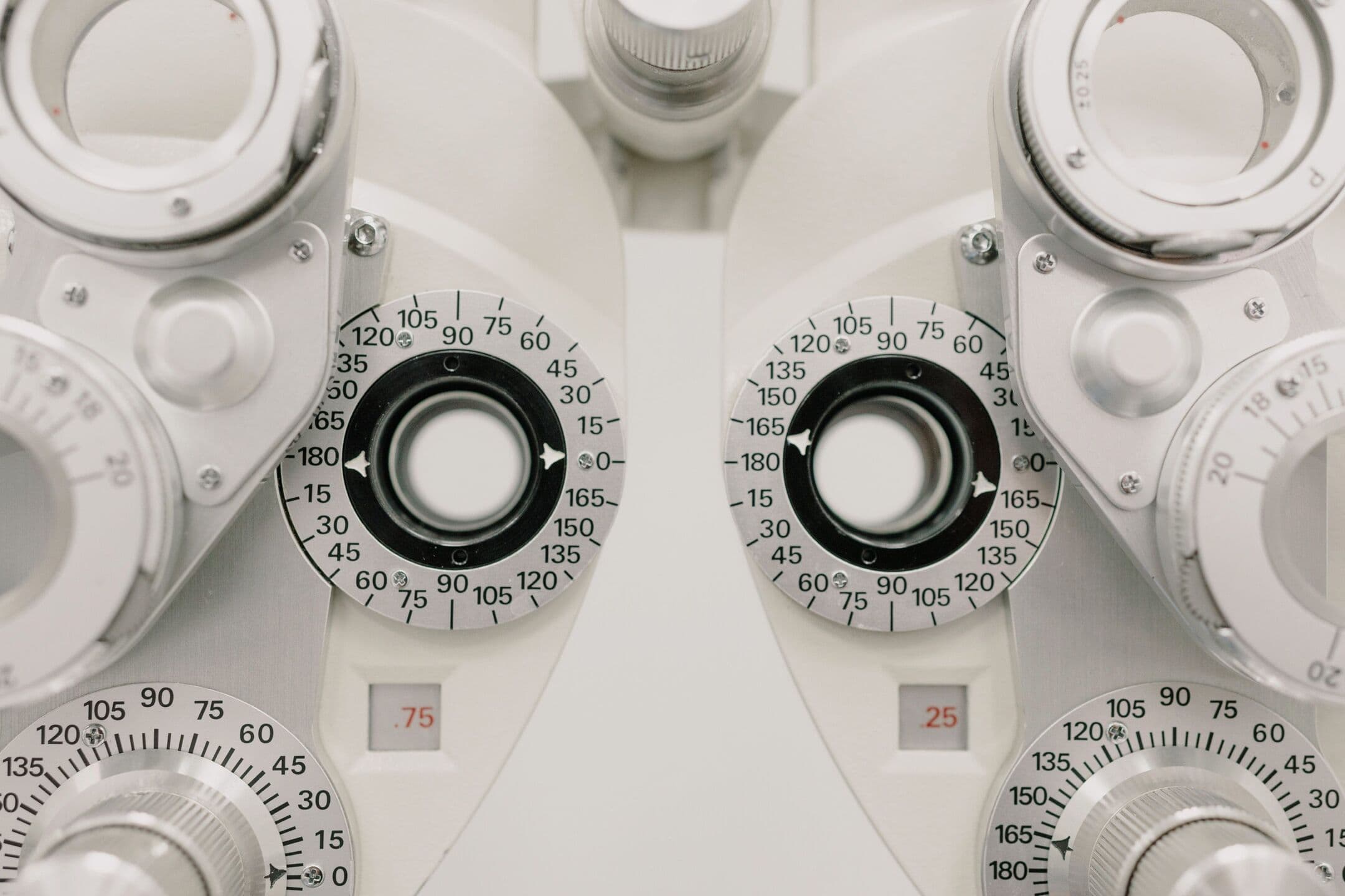 Close-up of the white lens dials of a phoropter, the instrument used to measure a glasses prescription