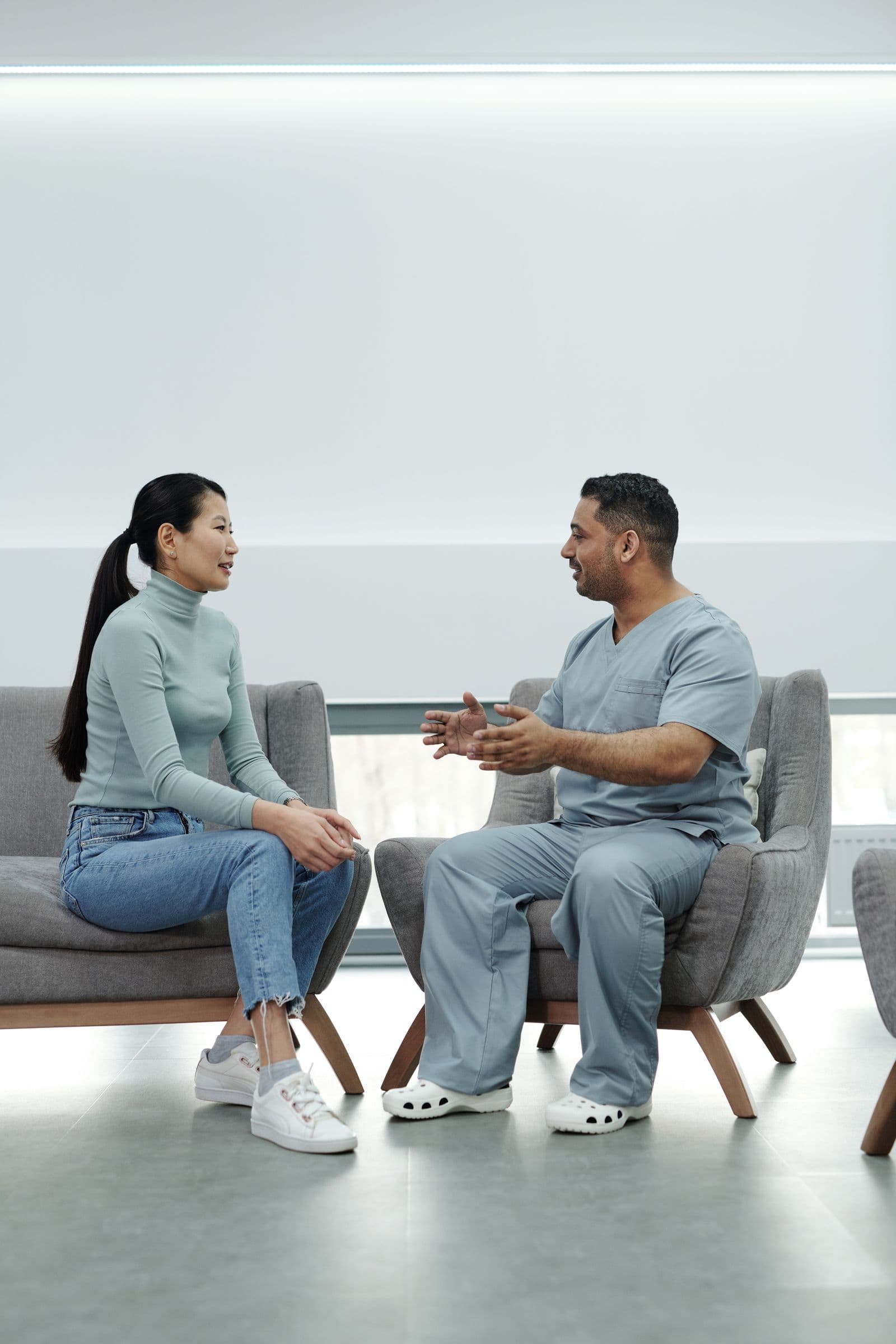 Clinician and patient talking face to face in a bright, calm room
