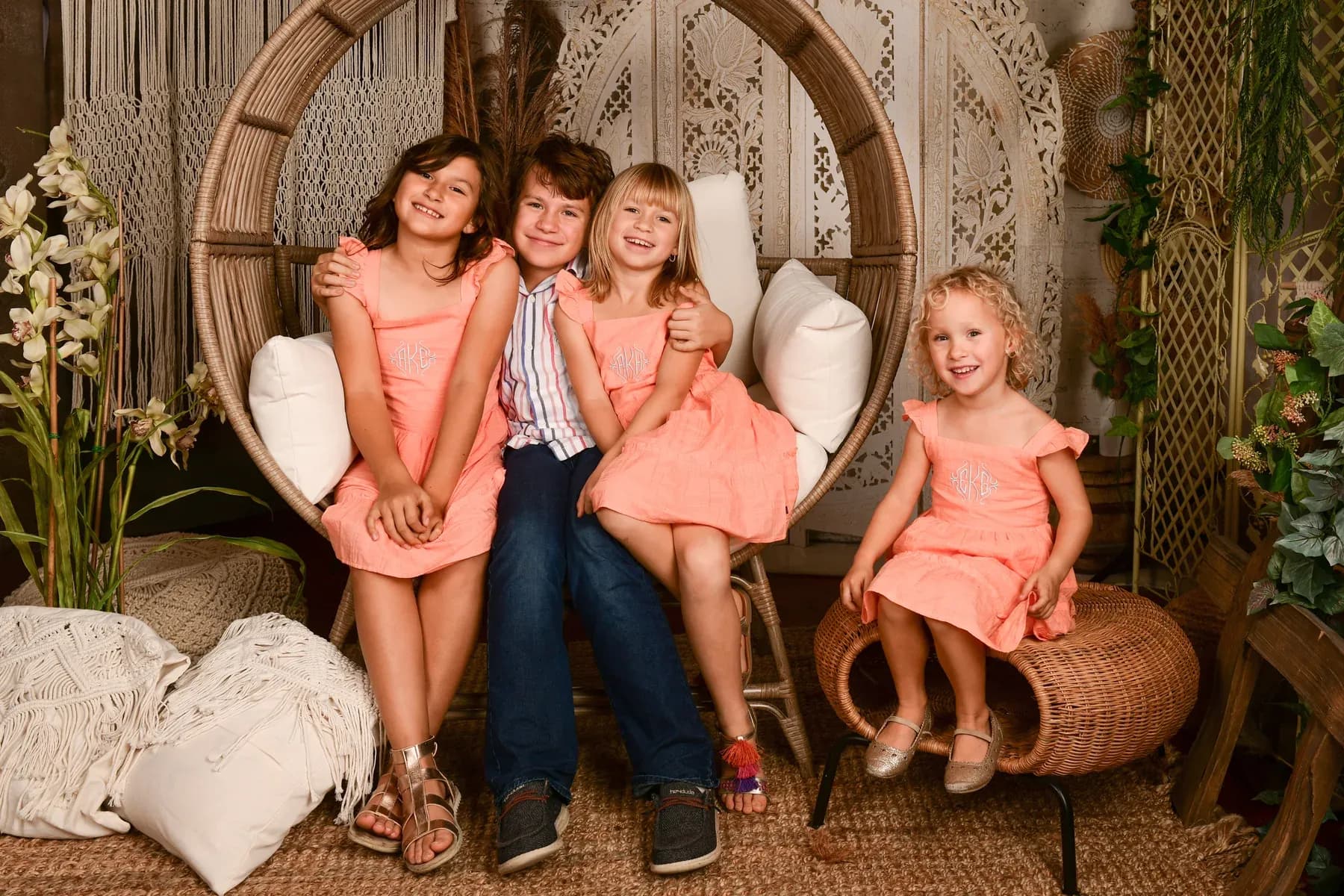 The four Thornton children smiling together in a rattan chair